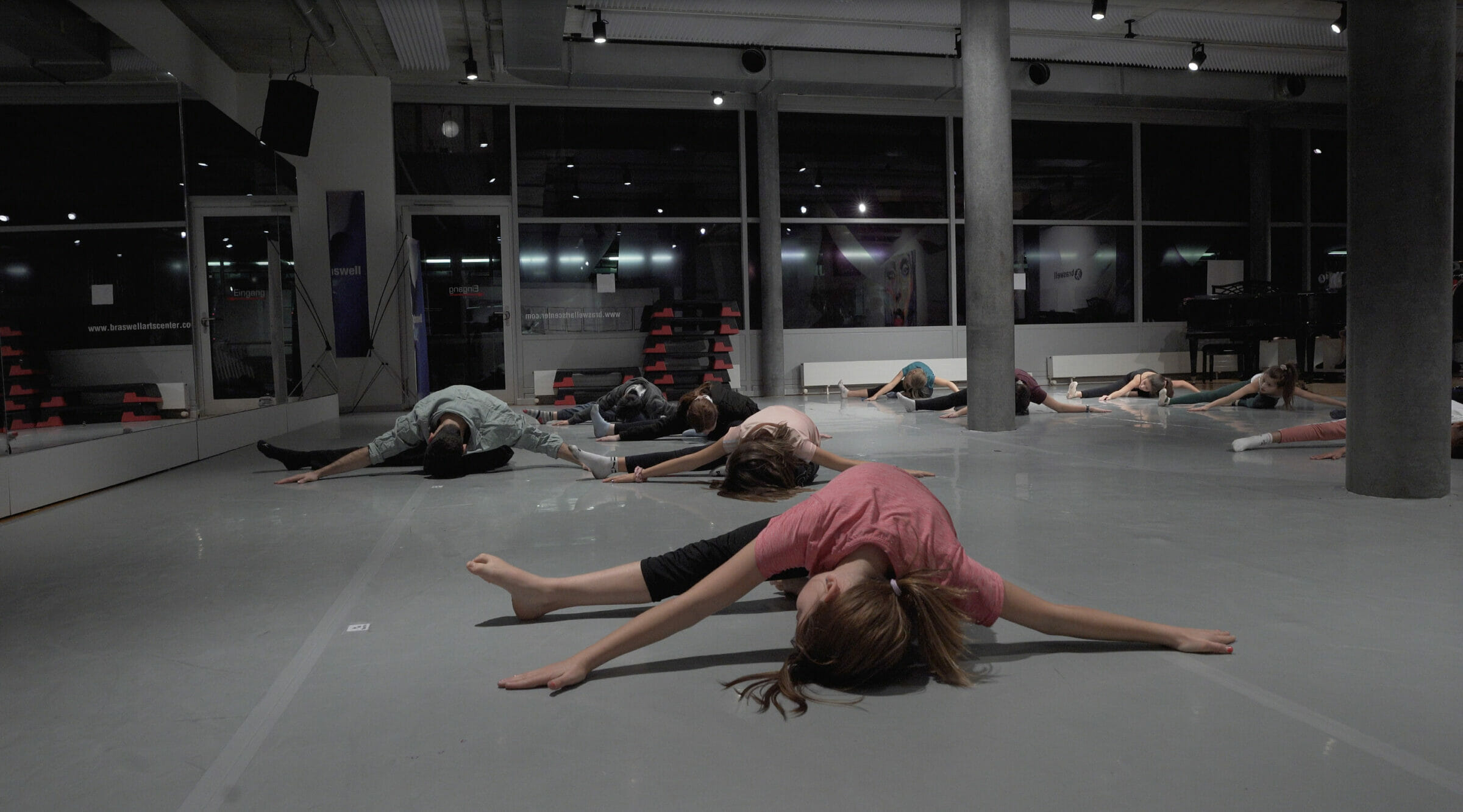 Teen dancers stretching together during a BAC class