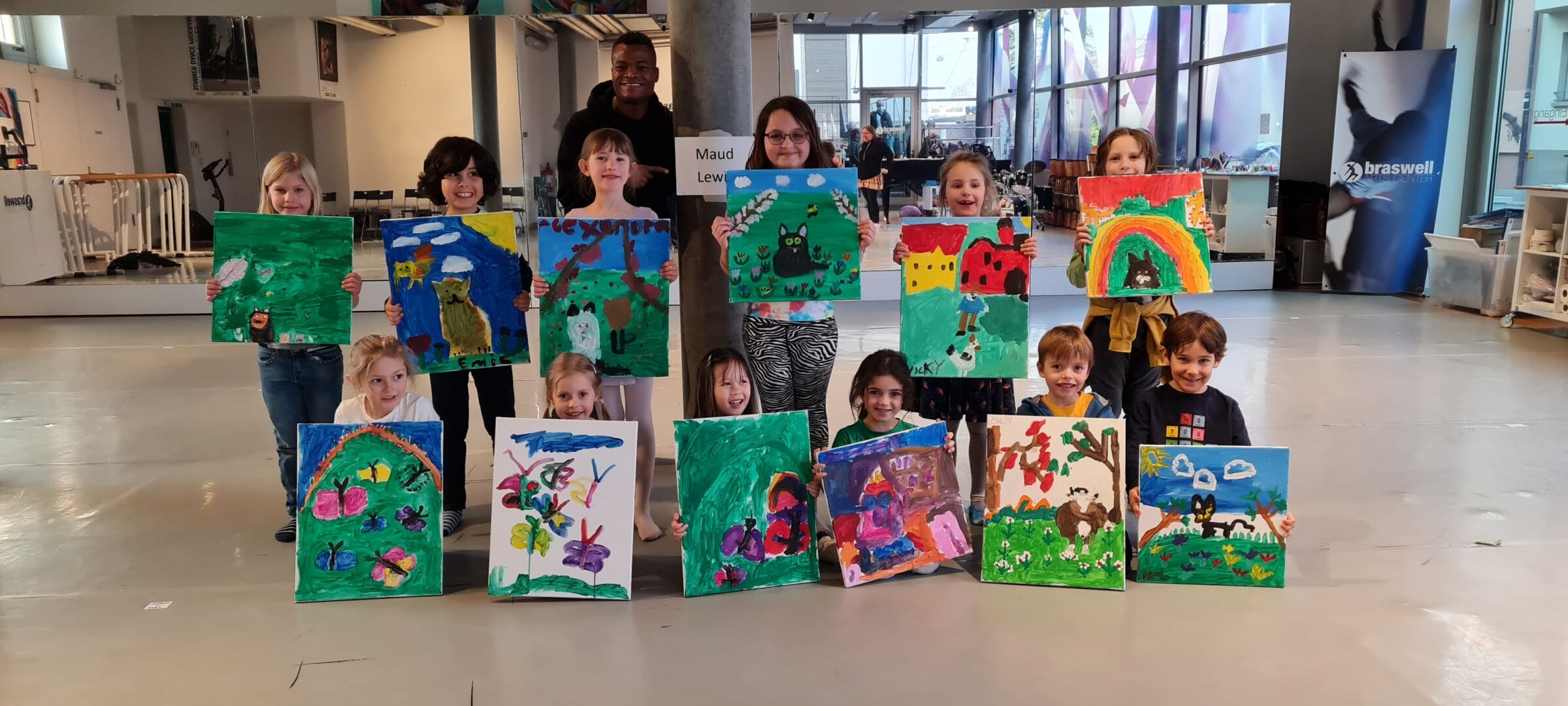 Children proudly showing their paintings at Fasnacht arts camp