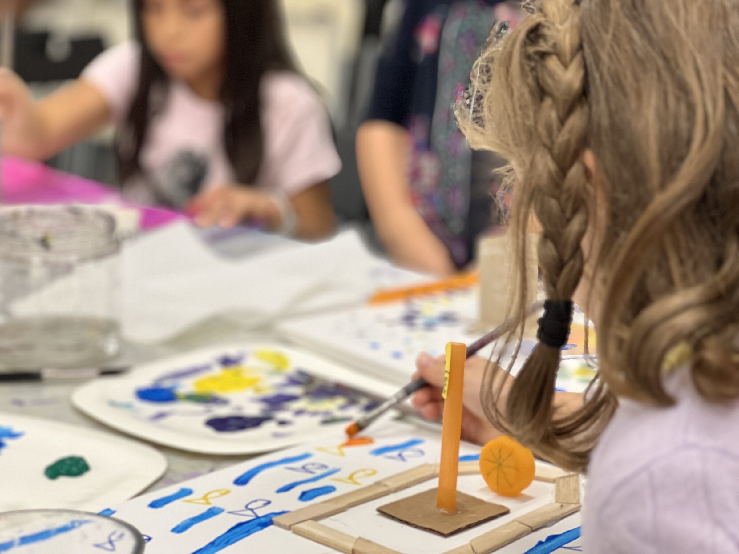 A camper concentrating on a colourful painting