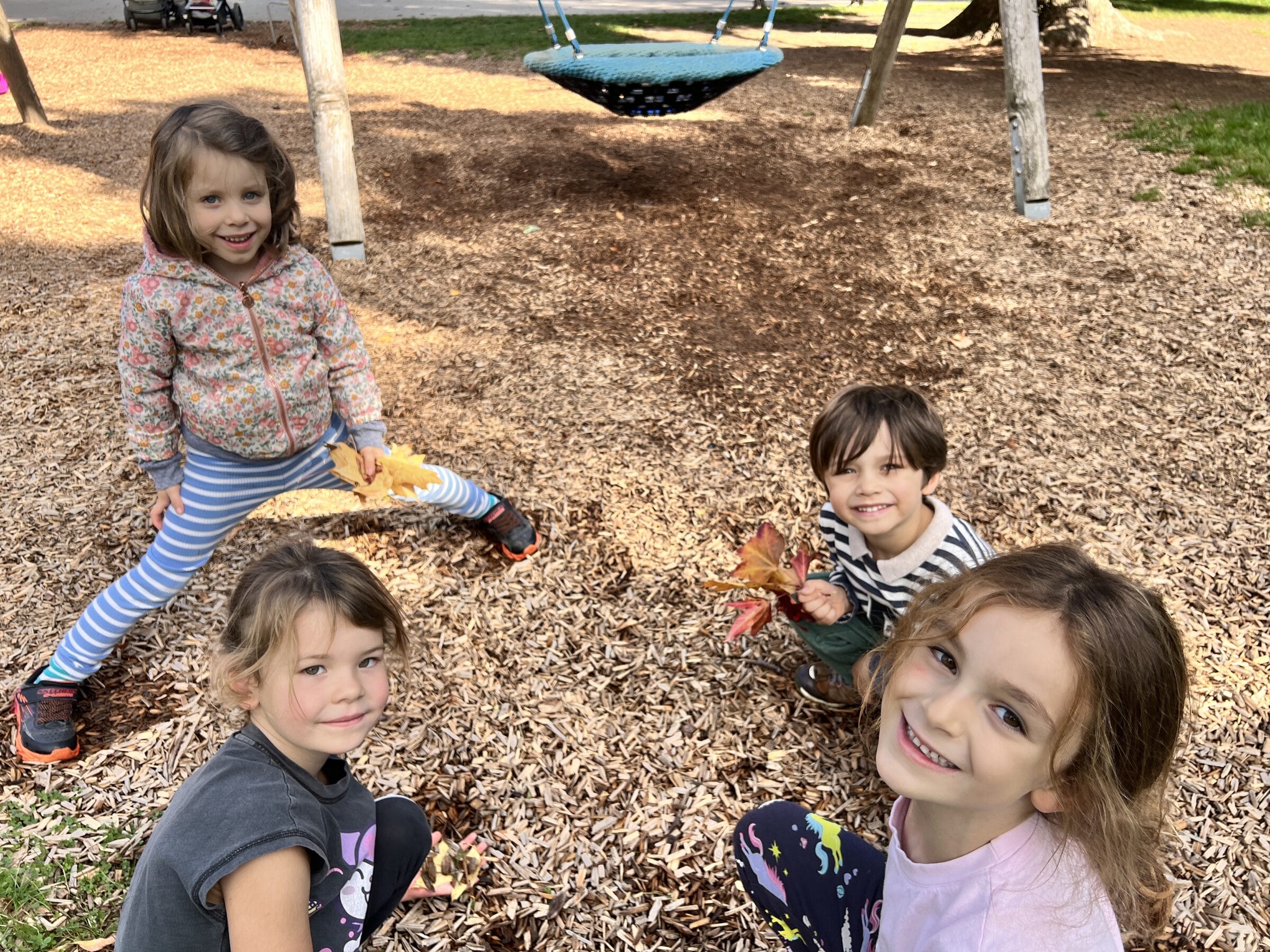 Autumn campers smiling together outdoors among fallen leaves