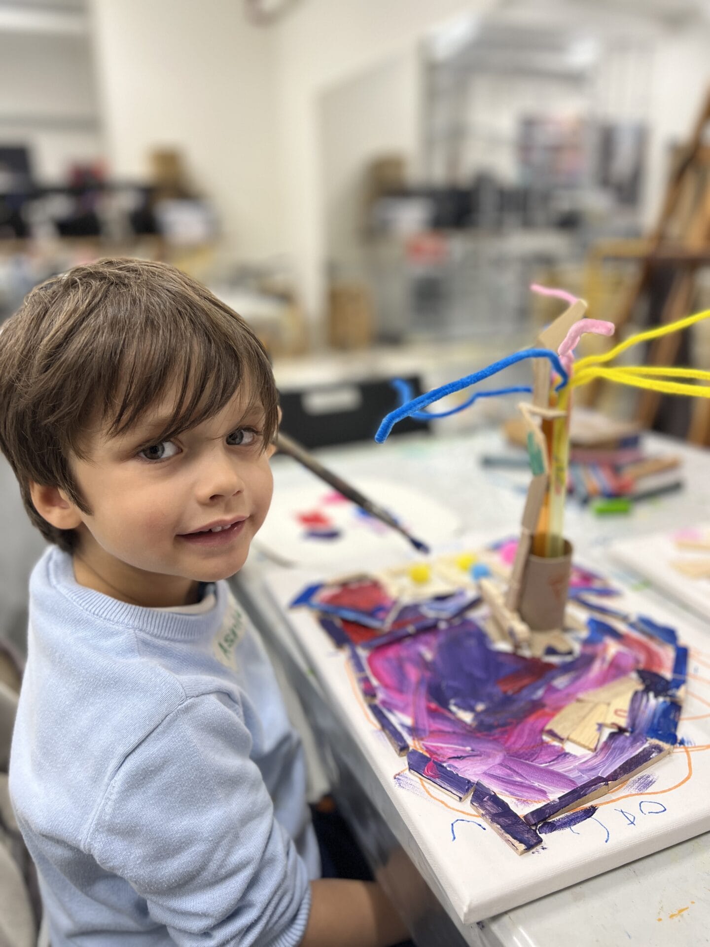 A child painting a colourful artwork at a BAC arts camp